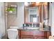 Cozy bathroom featuring dark wood vanity, granite countertop and decorative shelving at 7952 Diamond Rock Way # 102, Las Vegas, NV 89128