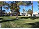 A well maintained green space with mature trees, covered parking, and residential buildings in the background at 7952 Diamond Rock Way # 102, Las Vegas, NV 89128