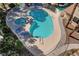 Aerial view of a kidney-shaped community pool with a hot tub and lounge chairs in a gated area at 7952 Diamond Rock Way # 102, Las Vegas, NV 89128
