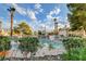 Beautiful community pool and well-maintained surrounding greenery and blue sky with palm trees at 7952 Diamond Rock Way # 102, Las Vegas, NV 89128
