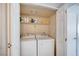 Functional laundry room with a washer, dryer, shelving and bi-fold doors at 7952 Diamond Rock Way # 102, Las Vegas, NV 89128