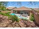 A backyard boasts a private swimming pool and an outdoor kitchen, nestled amongst lush greenery at 81 Alerion St, Las Vegas, NV 89138