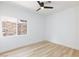 Clean bedroom featuring wood-look flooring, modern ceiling fan, and a large window overlooking landscaping at 81 Alerion St, Las Vegas, NV 89138