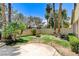Large backyard with a manicured lawn, palm trees, and a cozy fire pit area at 8113 Gothic Ave, Las Vegas, NV 89117