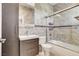 Modern bathroom featuring stylish vanity, tiled walls, and a shower-over-tub with glass doors at 8113 Gothic Ave, Las Vegas, NV 89117