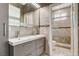 Modern bathroom with double vanity, gray tile, and glass shower door at 8113 Gothic Ave, Las Vegas, NV 89117