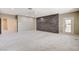 Spacious carpeted room featuring accent wall, ceiling fan, and access to the outside at 8113 Gothic Ave, Las Vegas, NV 89117