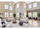 Stunning living room with soaring ceilings, large windows, elegant furnishings, and a stone accent wall at 8113 Gothic Ave, Las Vegas, NV 89117