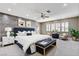 Staged main bedroom with wood accent wall, fan, shutters, bed, and blue furniture at 8113 Gothic Ave, Las Vegas, NV 89117