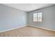 Bedroom featuring wood-look flooring, blue walls, and a metal security window at 813 E Bartlett Ave, North Las Vegas, NV 89030