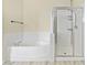 This bathroom offers tile flooring, separate tub and shower with white tile, and a towel rack on the wall at 8221 Stoneheather Ct, Las Vegas, NV 89117