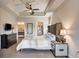 This bedroom is equipped with a ceiling fan, TV, dark dresser, and ensuite bathroom at 83 E Agate Ave # 207, Las Vegas, NV 89123