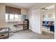 Bright bedroom features a work station near the window and an open door at 83 E Agate Ave # 207, Las Vegas, NV 89123
