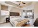 Bedroom featuring a comfortable bed, two windows with blinds, and a study area at 83 E Agate Ave # 207, Las Vegas, NV 89123