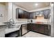 Well-lit kitchen showcases dark cabinetry, stainless steel appliances, and granite countertops at 83 E Agate Ave # 207, Las Vegas, NV 89123