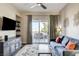 Bright living room with sliding glass doors leading to a balcony and cozy seating arrangement at 83 E Agate Ave # 207, Las Vegas, NV 89123