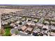A wide aerial shot of a neighborhood in a desert environment, featuring similar homes and a mountain range at 9008 Sawhill Pond St, Las Vegas, NV 89131