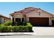 Inviting single-story home with a terracotta roof, a manicured lawn, and a convenient two-car garage at 9355 W Viking Rd, Las Vegas, NV 89147