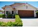 Beautiful single-story home with a terracotta roof, meticulously landscaped yard, and a wood-paneled two-car garage at 9355 W Viking Rd, Las Vegas, NV 89147