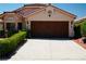 Charming single-story home featuring a brown wood garage door and well-manicured landscaping at 9355 W Viking Rd, Las Vegas, NV 89147
