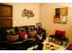 Cozy living room featuring a comfortable brown leather couch, colorful decor, and patterned rug at 9355 W Viking Rd, Las Vegas, NV 89147