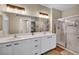 Bathroom featuring double sinks, a vanity, and a glass shower enclosure at 9431 Mad Dog St, Las Vegas, NV 89178