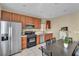 Bright kitchen boasts stainless steel refrigerator, gas range, and rich wood cabinetry at 9431 Mad Dog St, Las Vegas, NV 89178