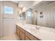 Bright bathroom with double vanity, large mirror, and natural light from a window at 1 Ibis Ct, Henderson, NV 89052