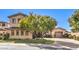 Charming front exterior with a lush green lawn, mature tree, and a two-car garage at 1 Ibis Ct, Henderson, NV 89052