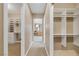 Hallway view featuring two walk-in closets with custom shelving, leading to a vanity area with natural light at 10156 Kearney Hill Pl, Las Vegas, NV 89144