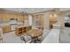 A spacious kitchen features light wood cabinetry, a center island, and a breakfast nook with a round table and chairs at 10156 Kearney Hill Pl, Las Vegas, NV 89144