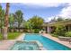 Backyard pool with a hot tub and patio, surrounded by lush landscaping at 10156 Kearney Hill Pl, Las Vegas, NV 89144