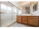 Bright bathroom featuring double sinks with wood cabinets and a shower with sliding glass doors at 1742 Ashburn Dr, North Las Vegas, NV 89032