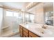 Bright bathroom featuring double sinks, a spacious walk-in shower, and ample lighting fixtures at 1742 Ashburn Dr, North Las Vegas, NV 89032