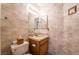 Cozy powder room includes a granite vanity top, wood cabinets, and wallpapered walls at 1742 Ashburn Dr, North Las Vegas, NV 89032