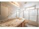 Well-lit bathroom featuring a granite countertop and a shower tub combination with glass doors at 1742 Ashburn Dr, North Las Vegas, NV 89032