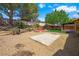 Spacious backyard featuring a gravel ground cover and a wooden deck surrounded by green trees at 1929 Stonington Pl, Las Vegas, NV 89108