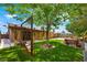 Relaxing backyard showcasing a wooden swing, mature tree, and a well-maintained lawn perfect for outdoor enjoyment at 1929 Stonington Pl, Las Vegas, NV 89108