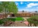 Expansive backyard featuring mature trees, lush green grass, a rustic bench, and an inviting fire pit area at 1929 Stonington Pl, Las Vegas, NV 89108