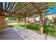 Backyard featuring a wooden pergola, green lawn, mature trees, and concrete patio at 1929 Stonington Pl, Las Vegas, NV 89108