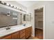 Bright bathroom featuring a double vanity and a walk-in closet with shelving for ample storage at 1929 Stonington Pl, Las Vegas, NV 89108