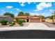 Charming single-story home with a well-manicured lawn, a tiled roof and a two-car garage at 1929 Stonington Pl, Las Vegas, NV 89108