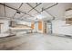Spacious garage with ample lighting, built-in shelving, and storage cabinets and work bench at 1929 Stonington Pl, Las Vegas, NV 89108