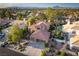 An aerial view showcases the lushly landscaped property and neighborhood with mountain views at 2108 Inverness Dr, Henderson, NV 89074