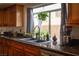Close-up of a kitchen sink with granite countertops, a window with plants, and stainless steel fixtures at 2108 Inverness Dr, Henderson, NV 89074