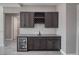 Stylish wet bar with a wine rack, modern fixtures, under-counter beverage cooler, and subway tile backsplash at 2650 Underbrush Ave, Pahrump, NV 89048