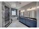 Luxurious bathroom featuring a soaking tub, walk-in shower with marble surround, and dual sink vanity at 2650 Underbrush Ave, Pahrump, NV 89048
