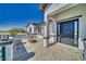 Stylish front porch area with a black front door, concrete flooring, and a modern gas burning fire pit at 2650 Underbrush Ave, Pahrump, NV 89048