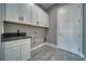 Clean laundry room with gray walls, stone countertop and modern cabinets at 2650 Underbrush Ave, Pahrump, NV 89048