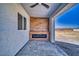 Covered patio featuring a modern fireplace with wood-look tile, ceiling fan, and scenic outdoor views at 2650 Underbrush Ave, Pahrump, NV 89048